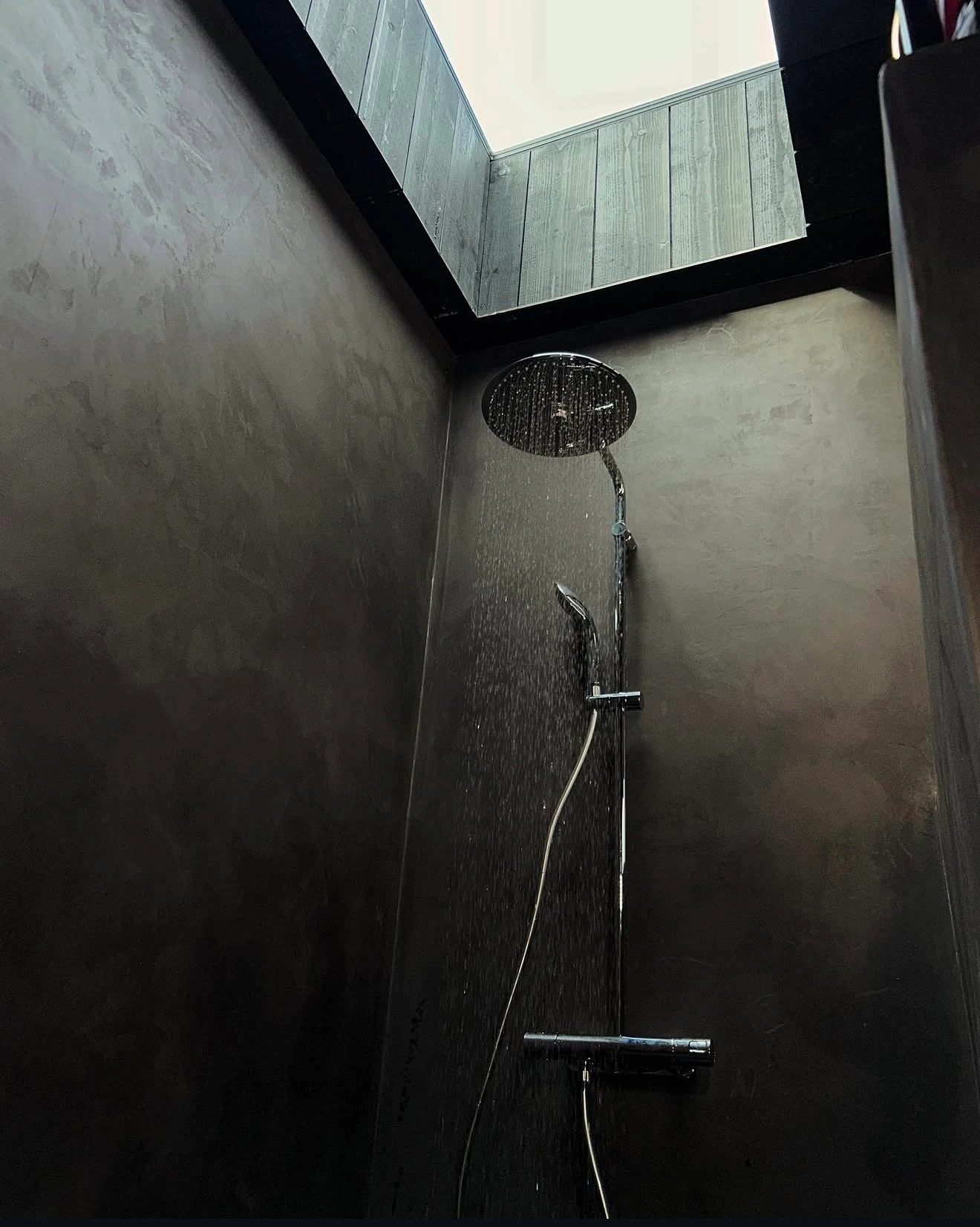 Hantverkare i blå arbetskläder arbetar med rör i vägg under renovering.