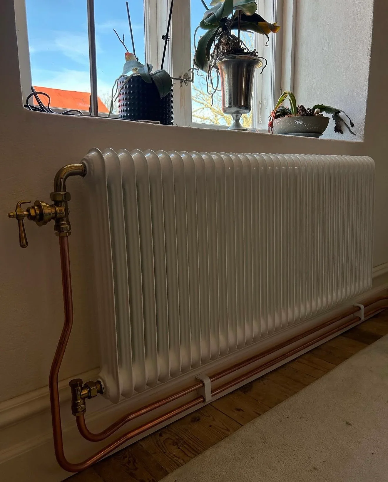 VVS-montör installerar rör och kopplingar i värmesystem med verktyg